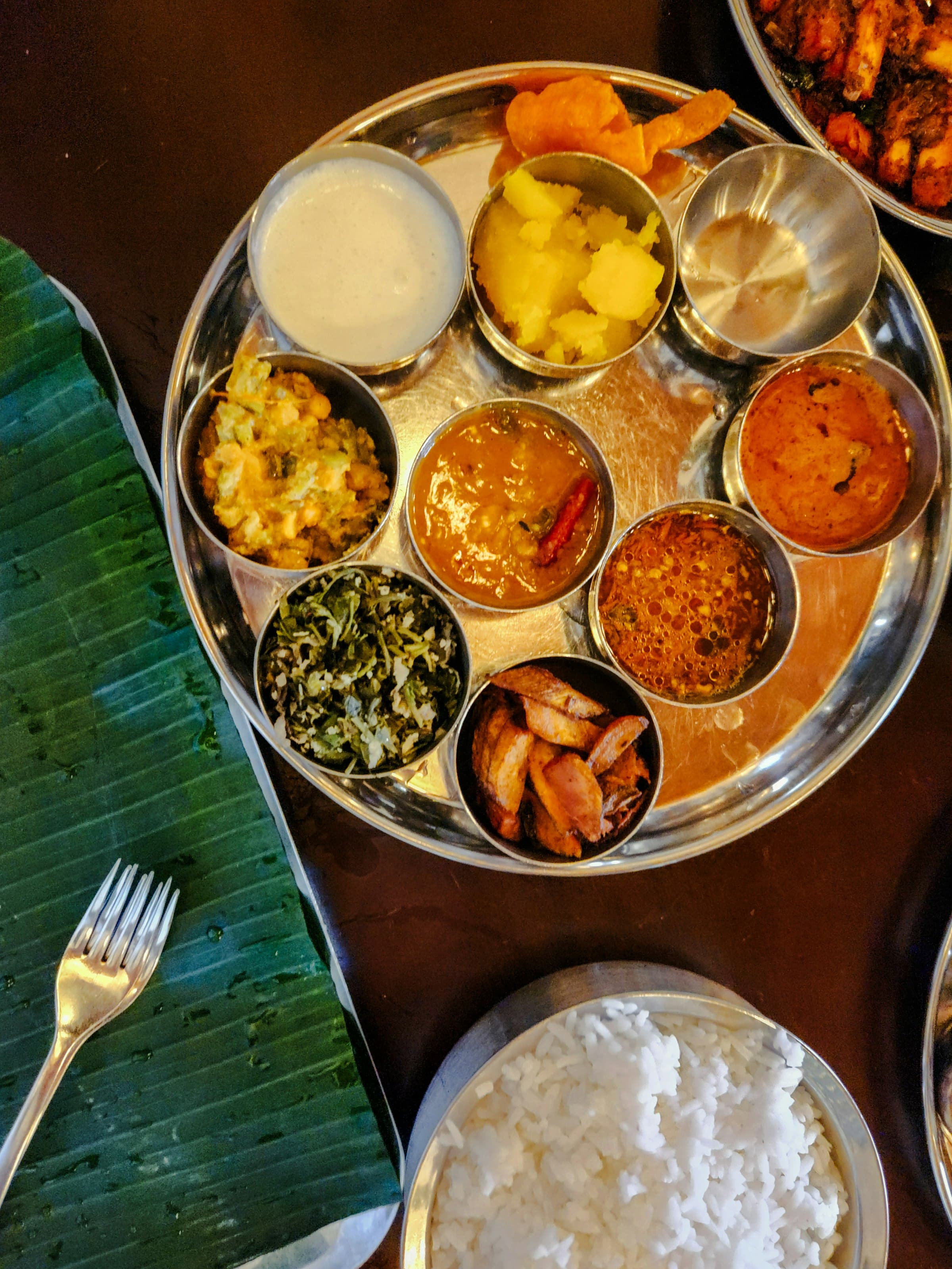 A thali of curries served on a banana leaf